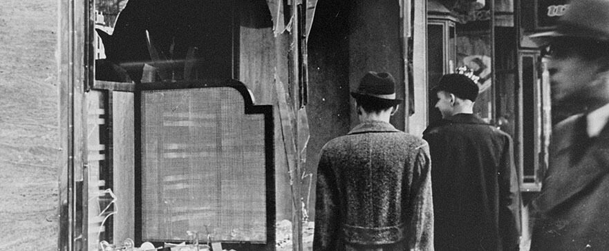 Men in front of Jewish shop with broken windows