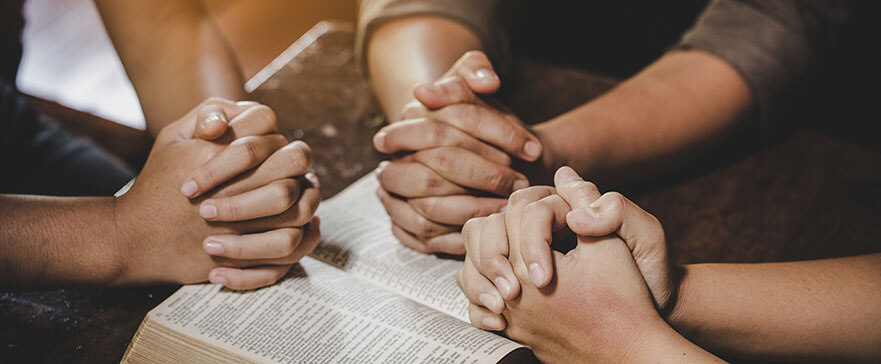 Group of different women praying together